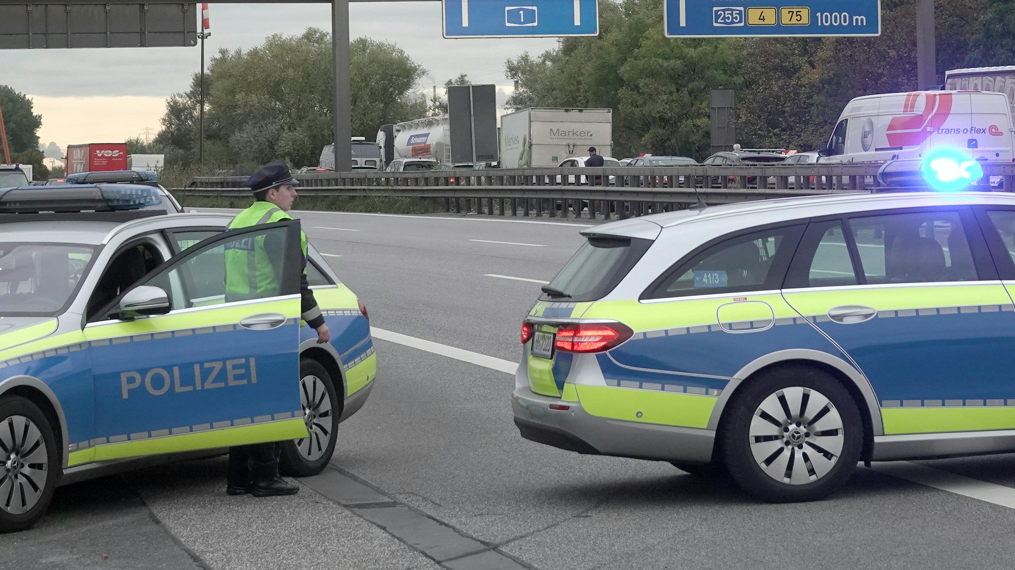 Einsatzfahrzeuge der Polizei stehen auf der gesperrten Autobahn 1.