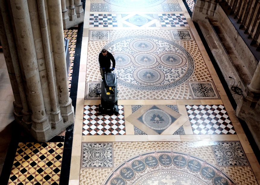 Mitarbeiter der Dombauhütte reinigen den historischen Sandsteinboden und den Mosaikboden im Kölner Dom.