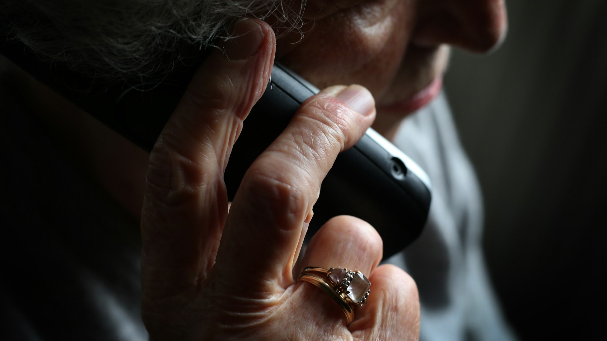 Eine ältere Frau telefoniert mit einem schnurlosen Festnetztelefon. Viele ältere Menschen fallen immer wieder auf den sogenannten Enkeltrick herein.