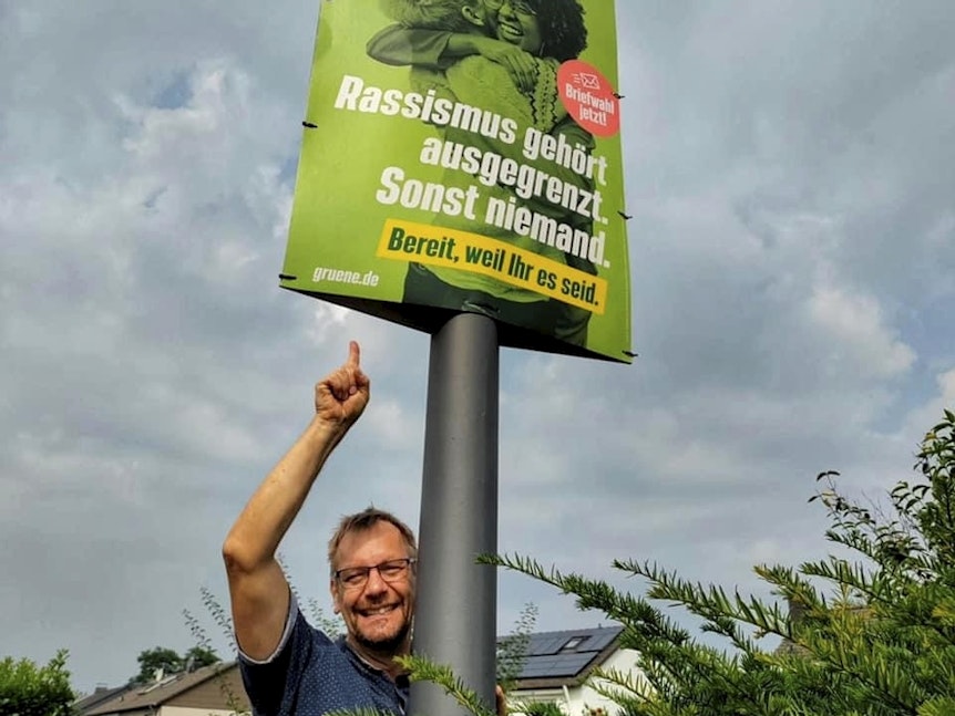 Plakathelfer Dirk Trapphagen mit einem Grünen-Plakat