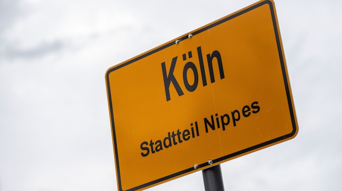 Ein gelbes Ortsschild mit dem Stadtnamen Köln und dem Stadtteil Nippes ist zu sehen.