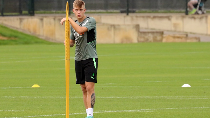 Gladbach neues Verteidiger-Talent Luca Netz beim Fohlen-Training am 7. August 2021 im Borussia-Park. Der 18-Jährige lehnt sich an einen Aufsteller an, der in den Rasen gesteckt worden ist.