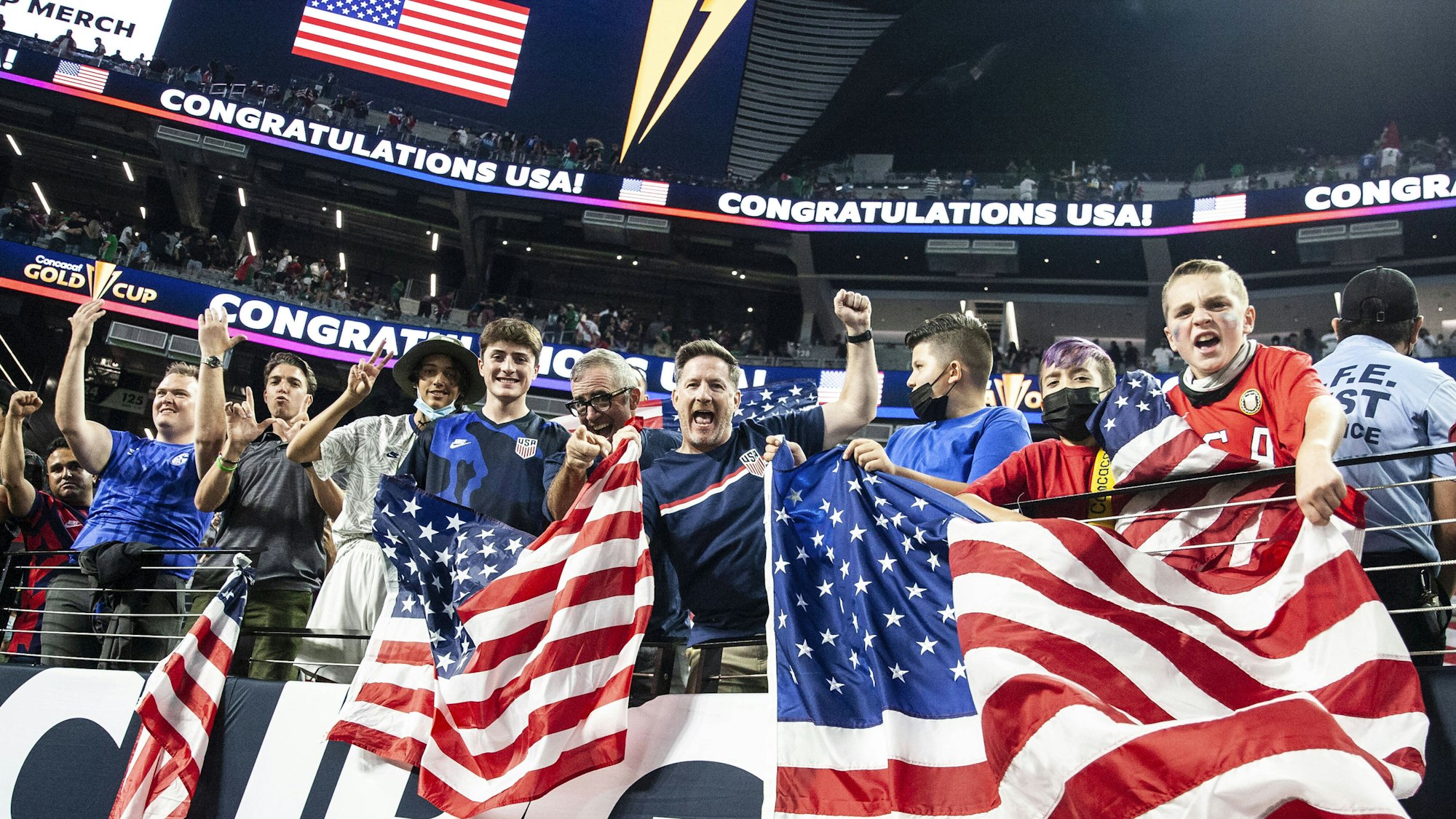 Fußballfans jubeln und schwenken US-amerikanische Flaggen.