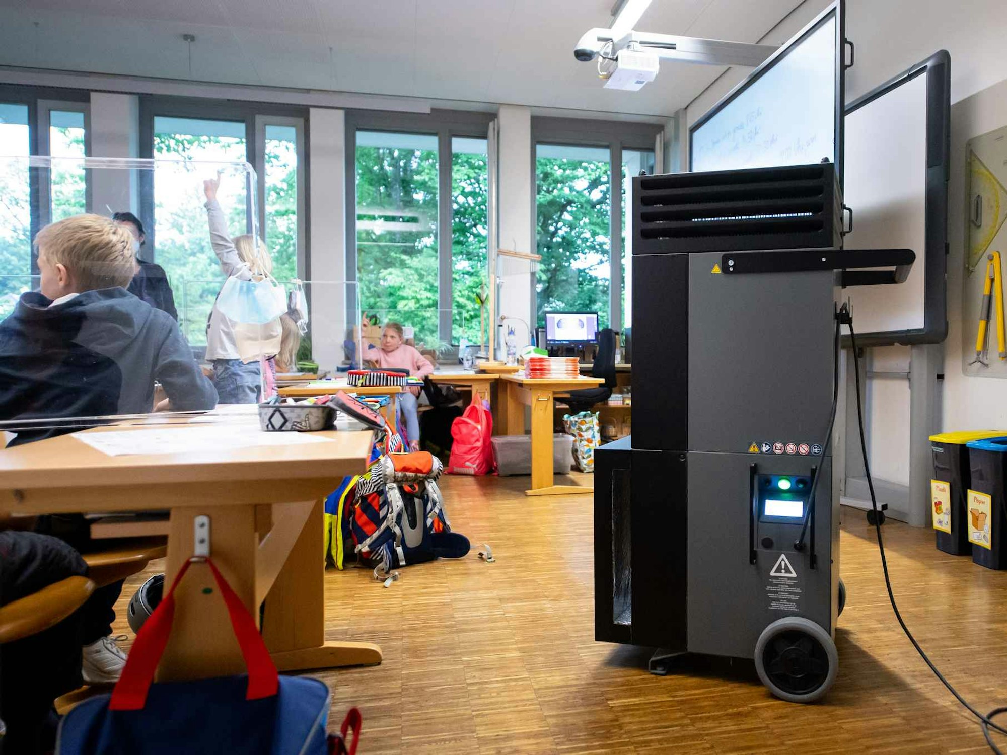 Ein Luftfiltergerät steht in einem Klassenraum an der Grundschule Neubiberg.