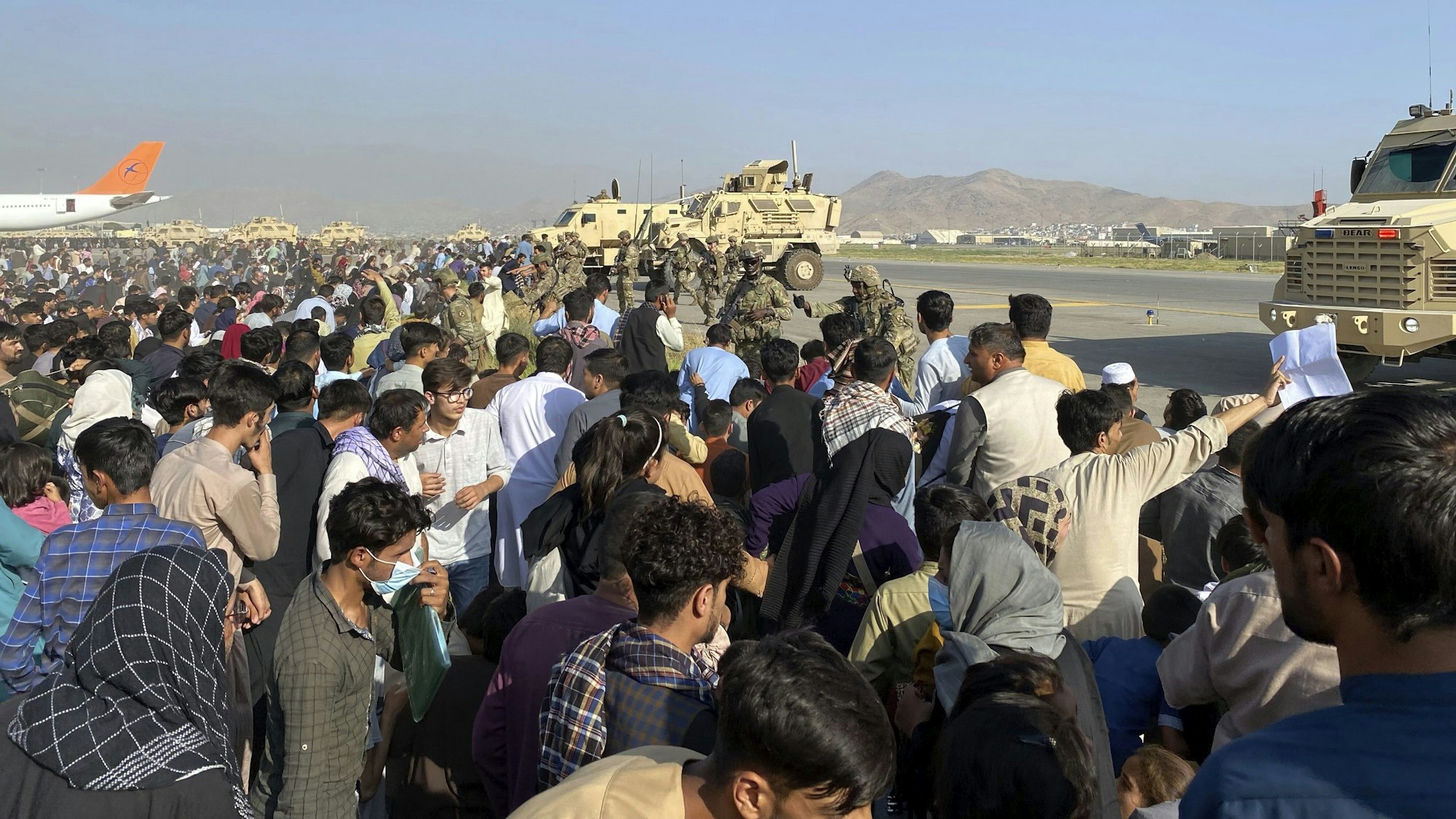 Hunderte Zivilisten stehen auf dem Flughafen von Kabul vor einer Militär-Absperrung.