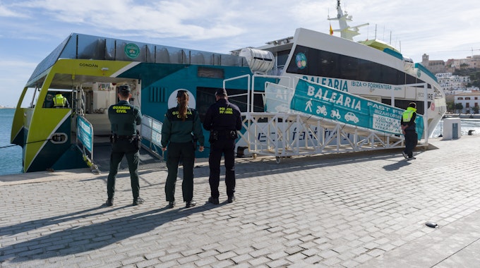 Polizisten vor einer Fähre im Hafen von Ibiza.