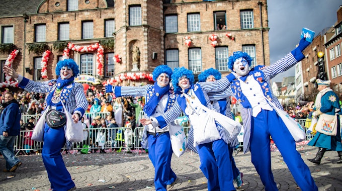 Karnevalisten einer Fußgruppe feiern beim Rosenmontagszug.