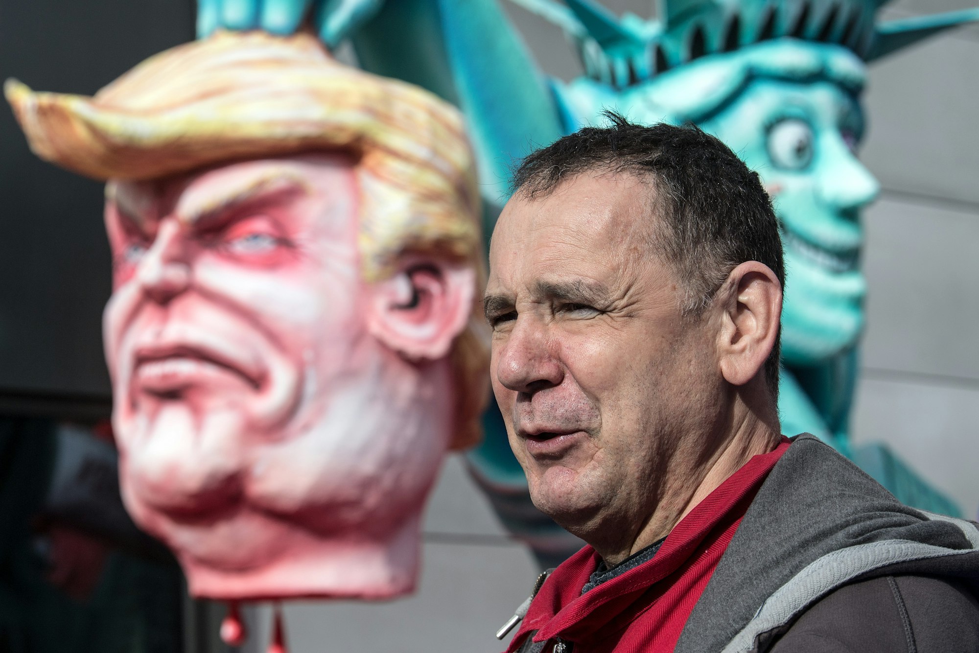 Wagenbauer Jacques Tilly steht in Düsseldorf vor seinen Karnevalswagen, die die Köpfe von US-Präsident Trump und die Freiheitsstatue zeigen.