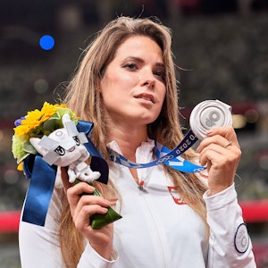 Die polnische Speerwerferin Maria Andrejczyk präsentiert ihr in Tokio gewonnene Olympia-Silbermedaille.