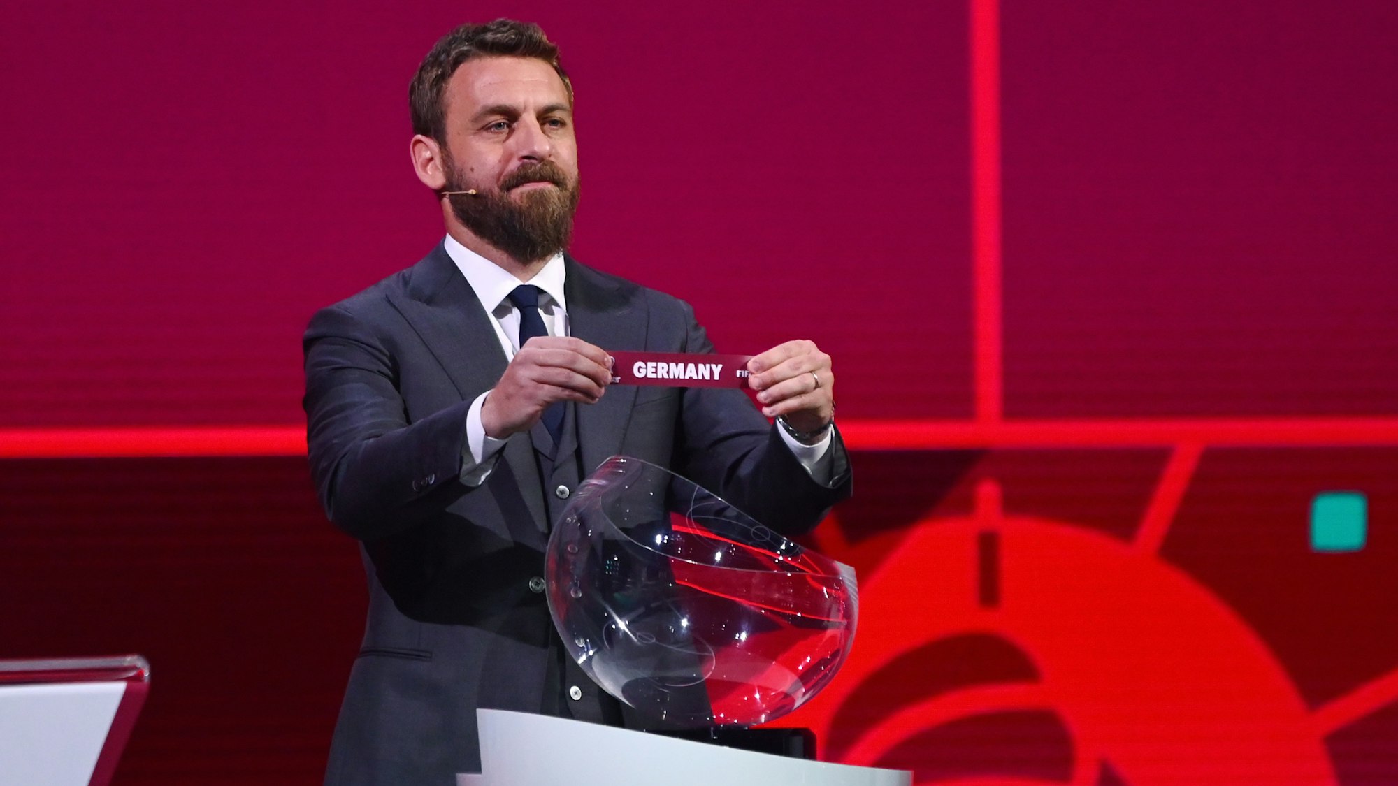 Daniele de Rossi hält bei der Auslosung zur Quali für die WM 2022 ein Los mit dem Schriftzug „Deutschland“ in der Hand.