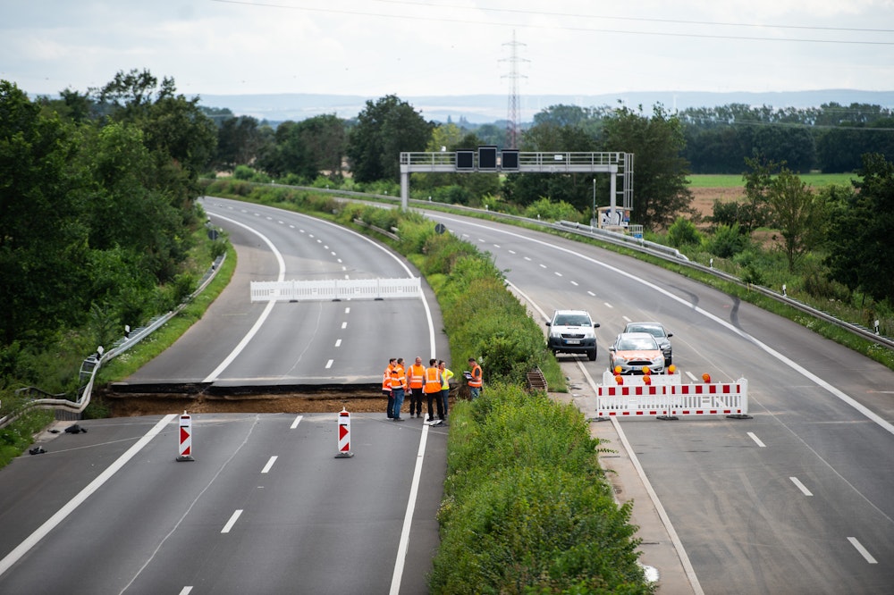 Arbeiter stehen auf der Autobahn A1 bei Erftstadt.