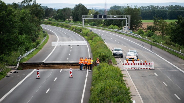 Arbeiter stehen auf der Autobahn A1 bei Erftstadt.