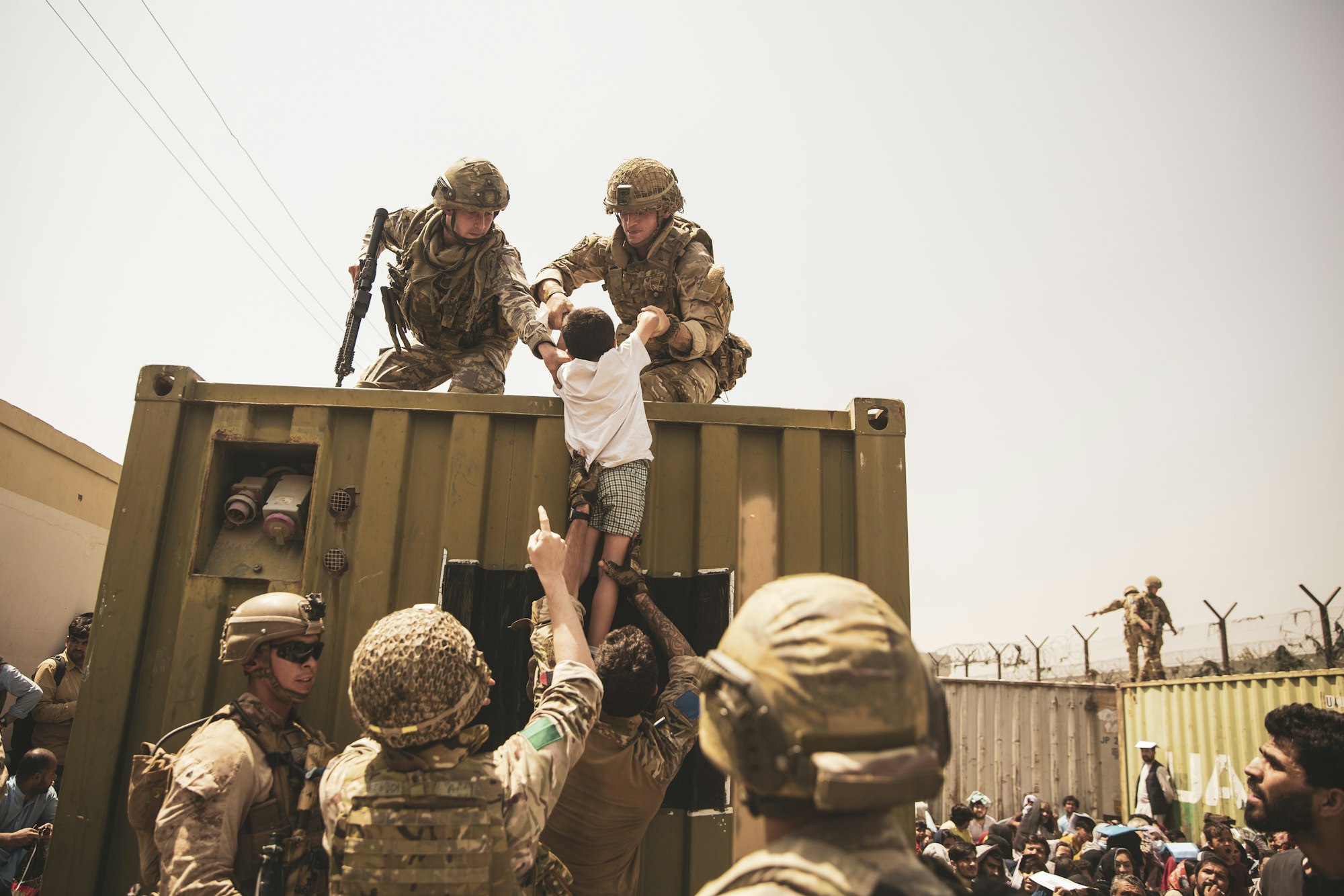 In diesem vom US Marine Corps zur Verfügung gestellten Foto helfen britische und türkische Koalitionstruppen zusammen mit US-Marines einem Kind während einer Evakuierung am Hamid Karzai International Airport.