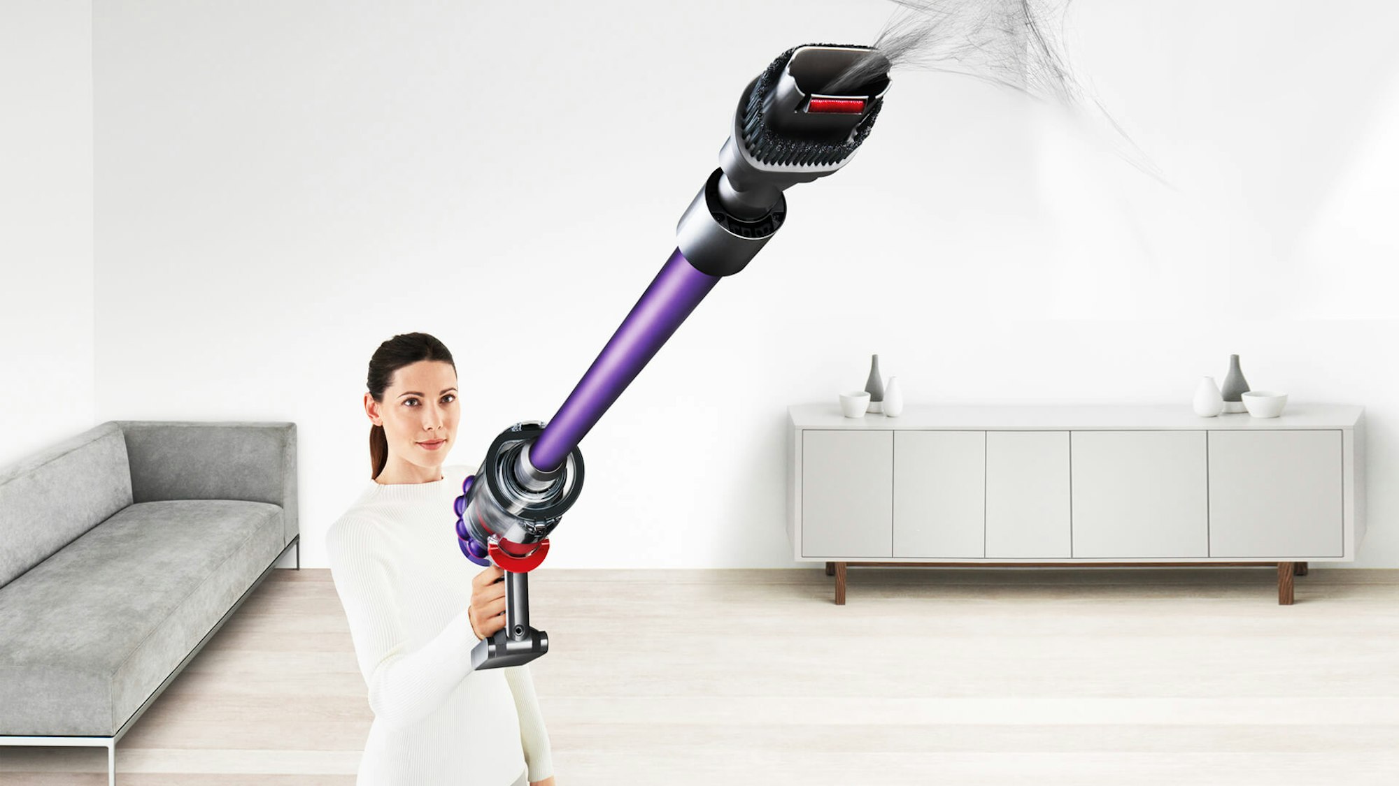 Eine Frau saugt die Wohnung mit einem kabellosen Dyson V11 Absolute Extra Pro Staubsauger.