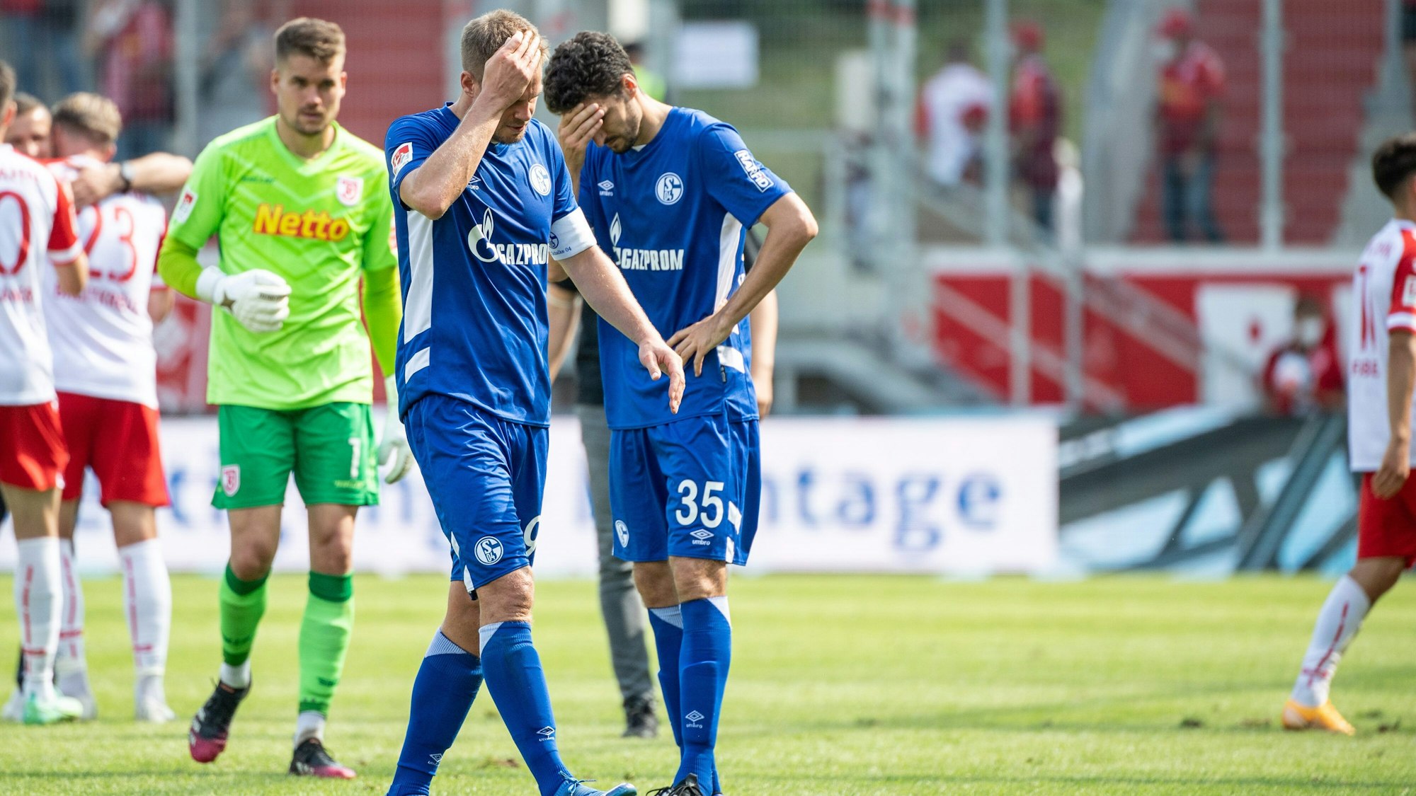 Simon Terodde (l.) und Marcin Kaminski von Schalke verlassen nach dem Spiel in Regensburg den Platz.