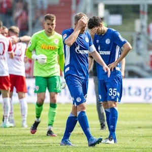 Simon Terodde (l.) und Marcin Kaminski von Schalke verlassen nach dem Spiel in Regensburg den Platz.