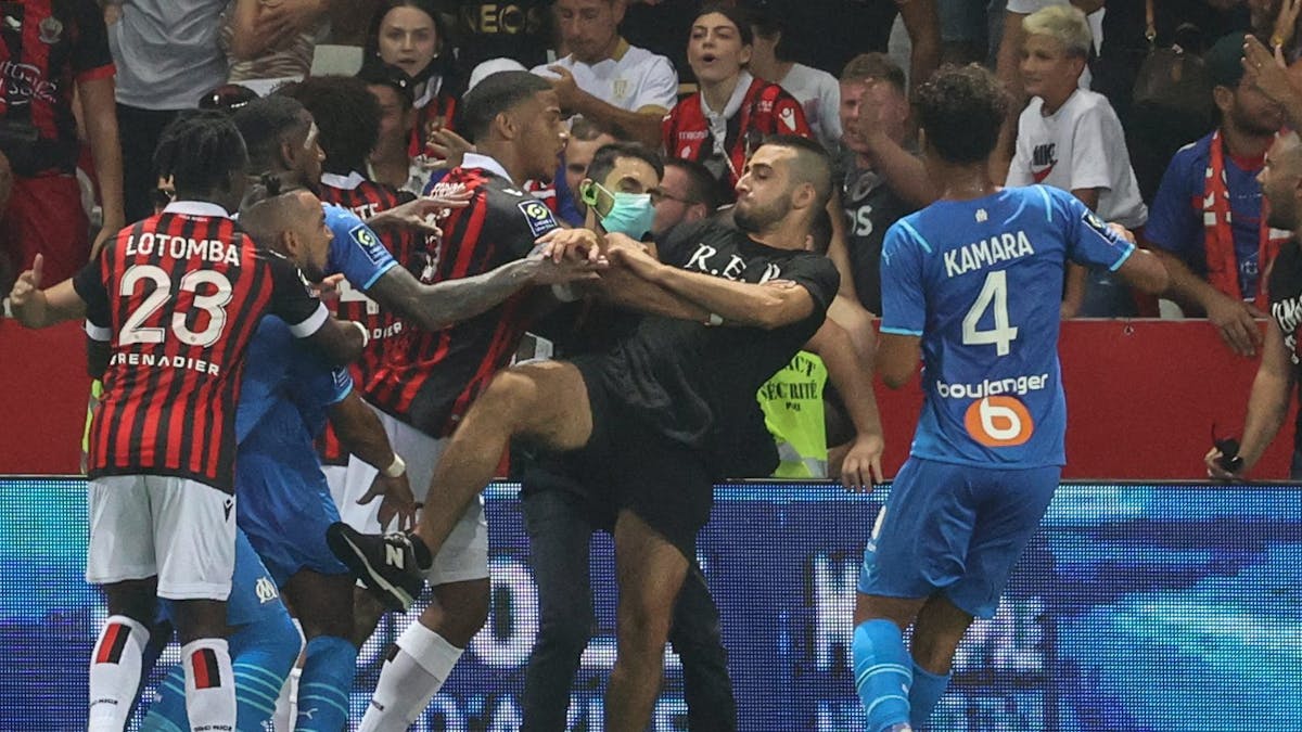 Spieler von Nizza und Marseille versuchen einen Fan am Platzsturm zu hindern.