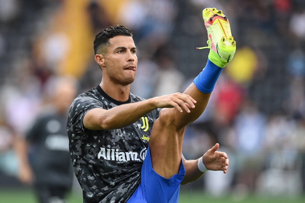 Cristiano Ronaldo hebt sein Bein beim Warmmachen auf Kopfhöhe.