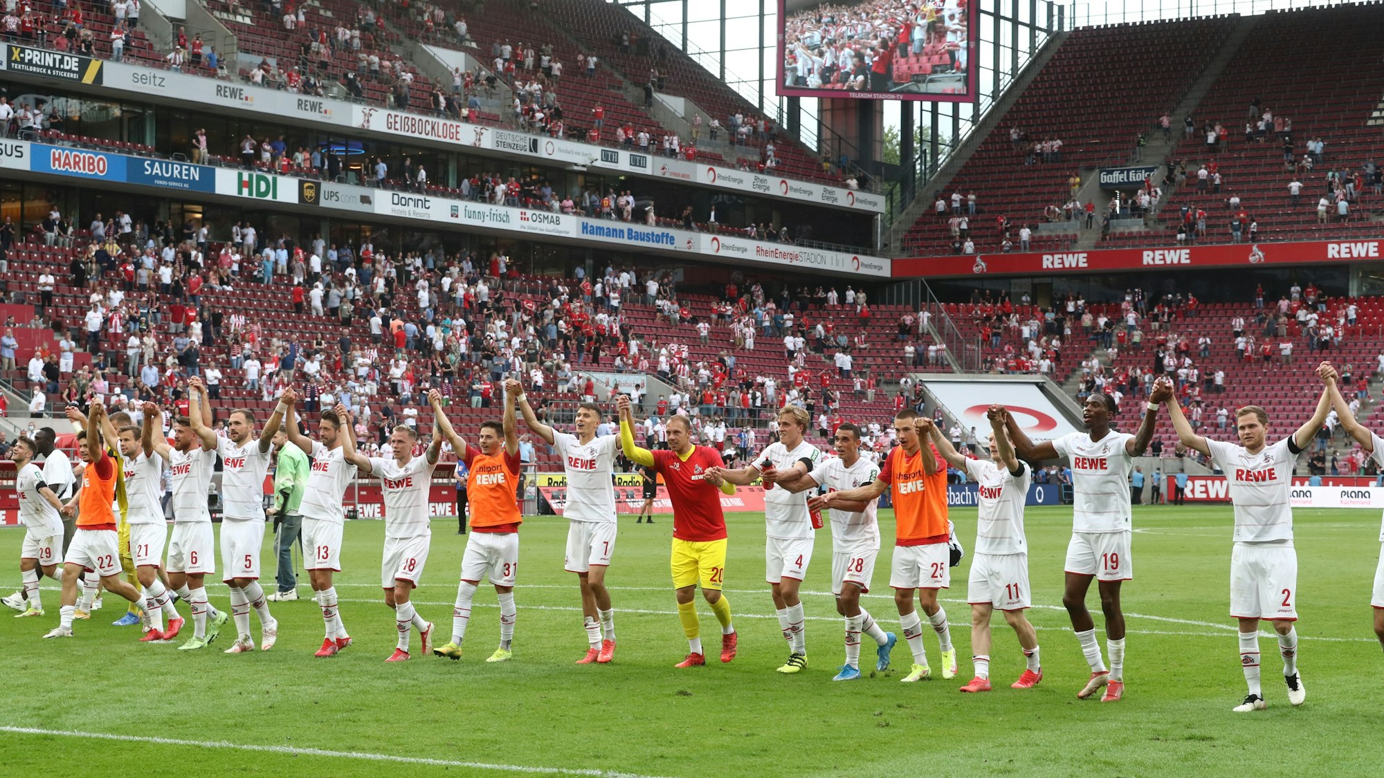 Die Spieler des 1. FC Köln jubeln mit ihren Fans.