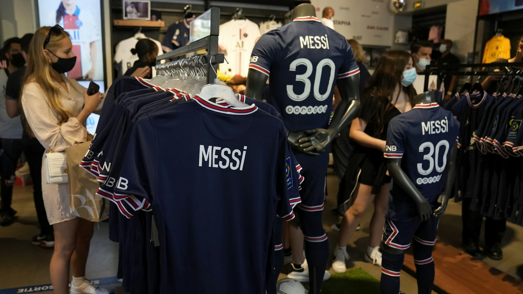 Fans schauen sich das Trikot von Lionel Messi im Fanshop von PSG an.