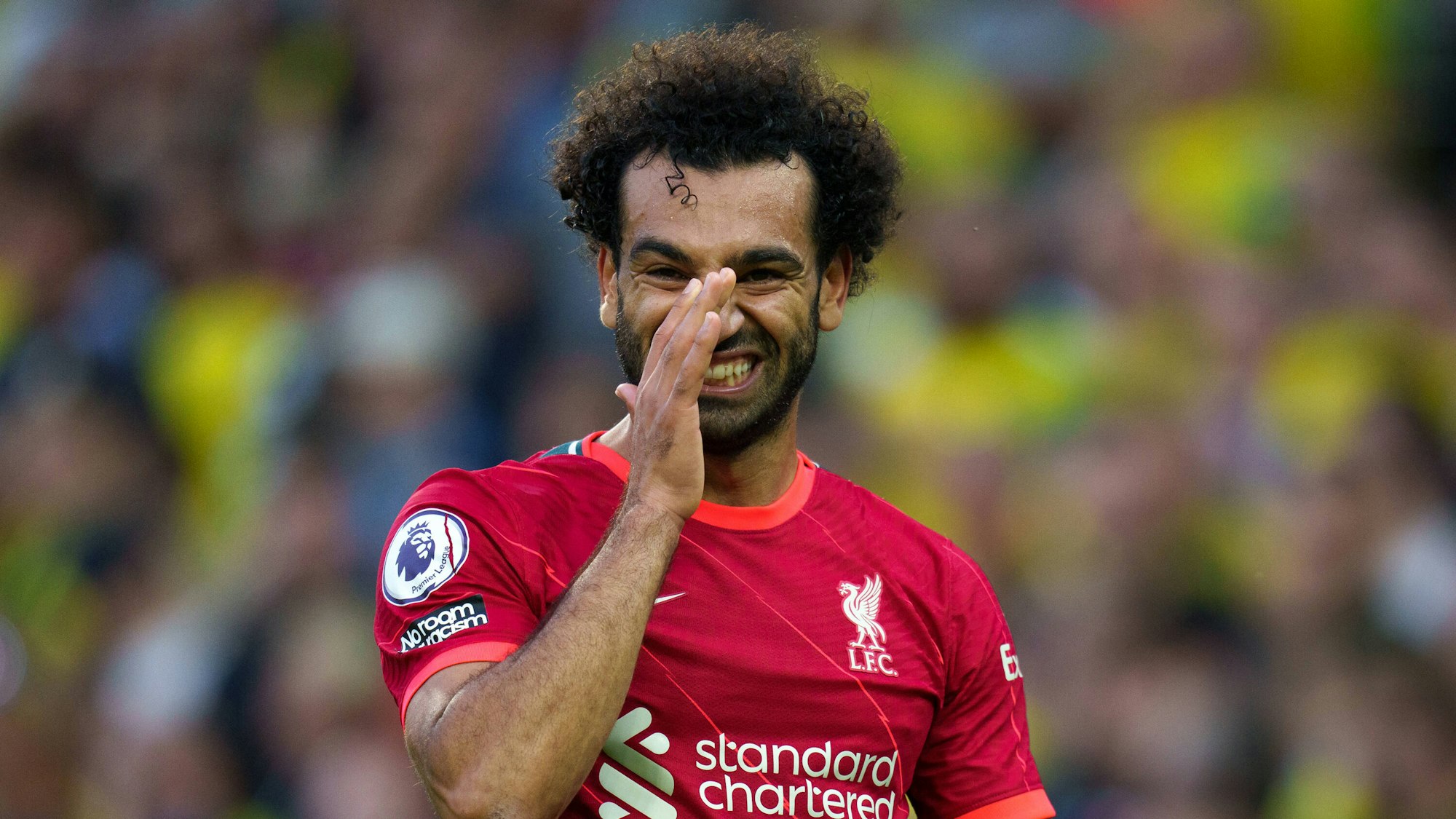 Mo Salah von Liverpool fasst sich mit der Hand in sein Gesicht und zeigt dabei seine Zähne.