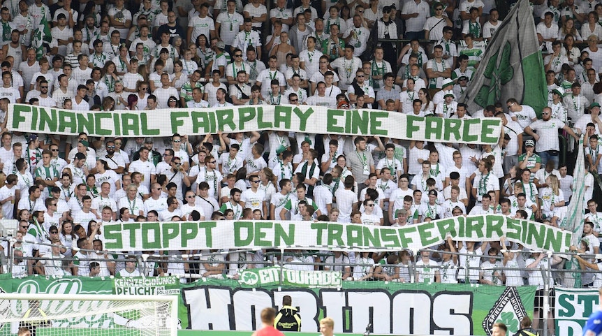 Fans von Greuther Fürth zeigen ein Banner mit dem Schriftzug „Financial Fairplay eine Farce, stoppt den Transferwahnsinn!“