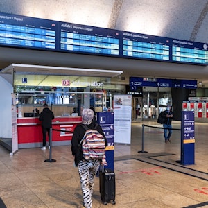 Menschen am Infostand im Hauptbahnhof Köln.