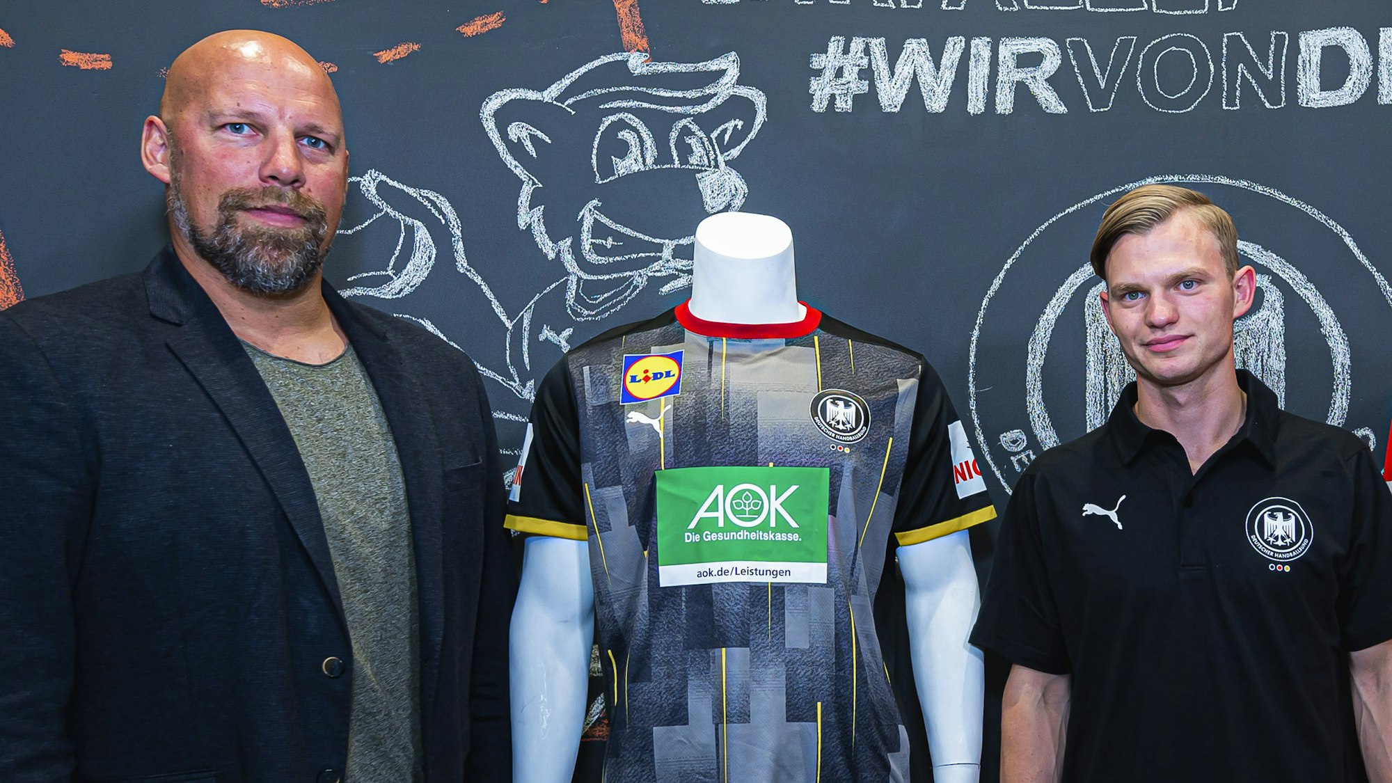 Axel Kromer und Timo Kastening präsentieren die neuen Trikots des deutschen Handball-Bundes.