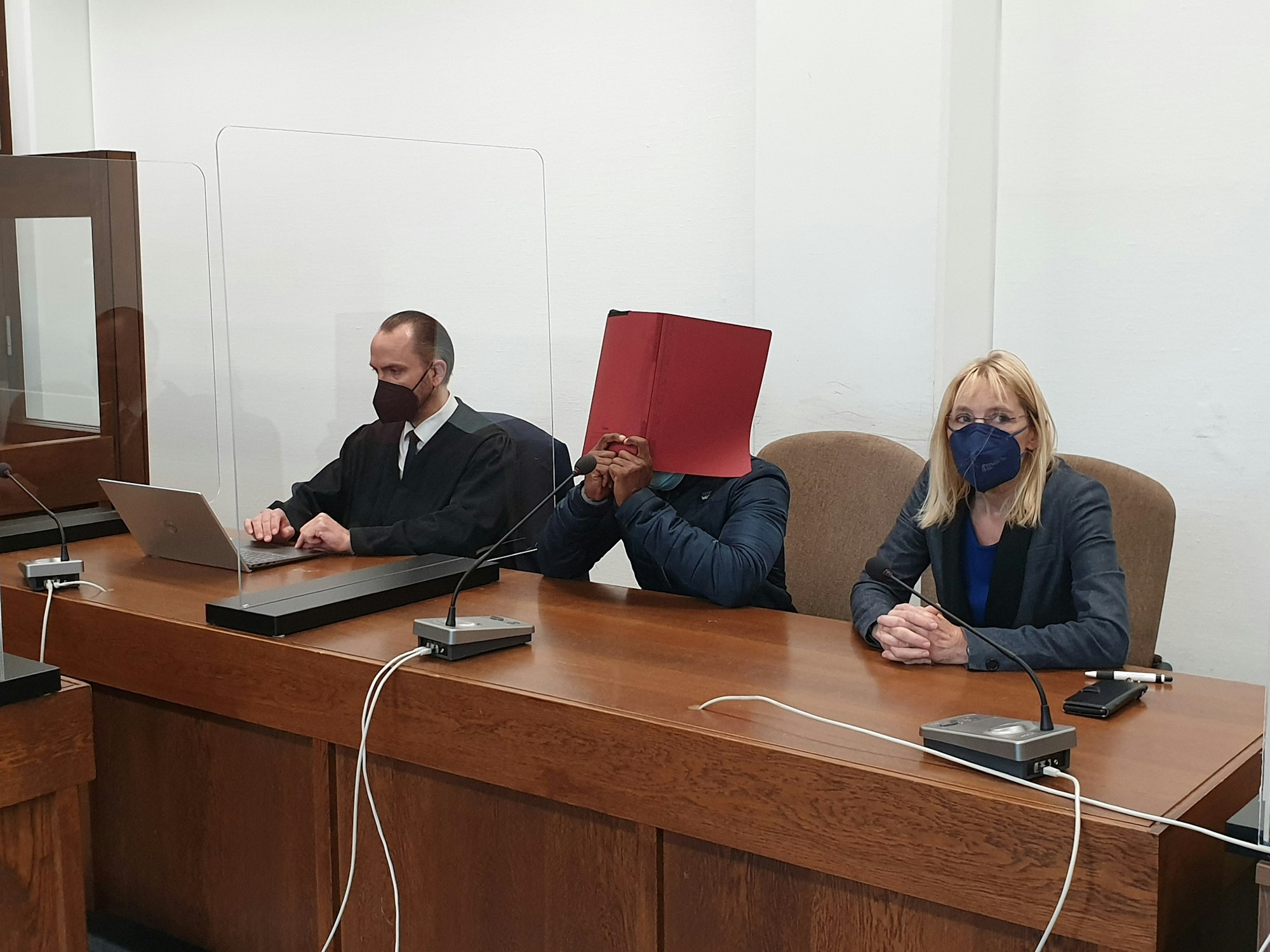 Auf der Anklagebank im Kölner Landgericht sitzt der Angeklagte zusammen mit seiner Dolmetscherin und Rechtsanwalt Carsten Göthel. 