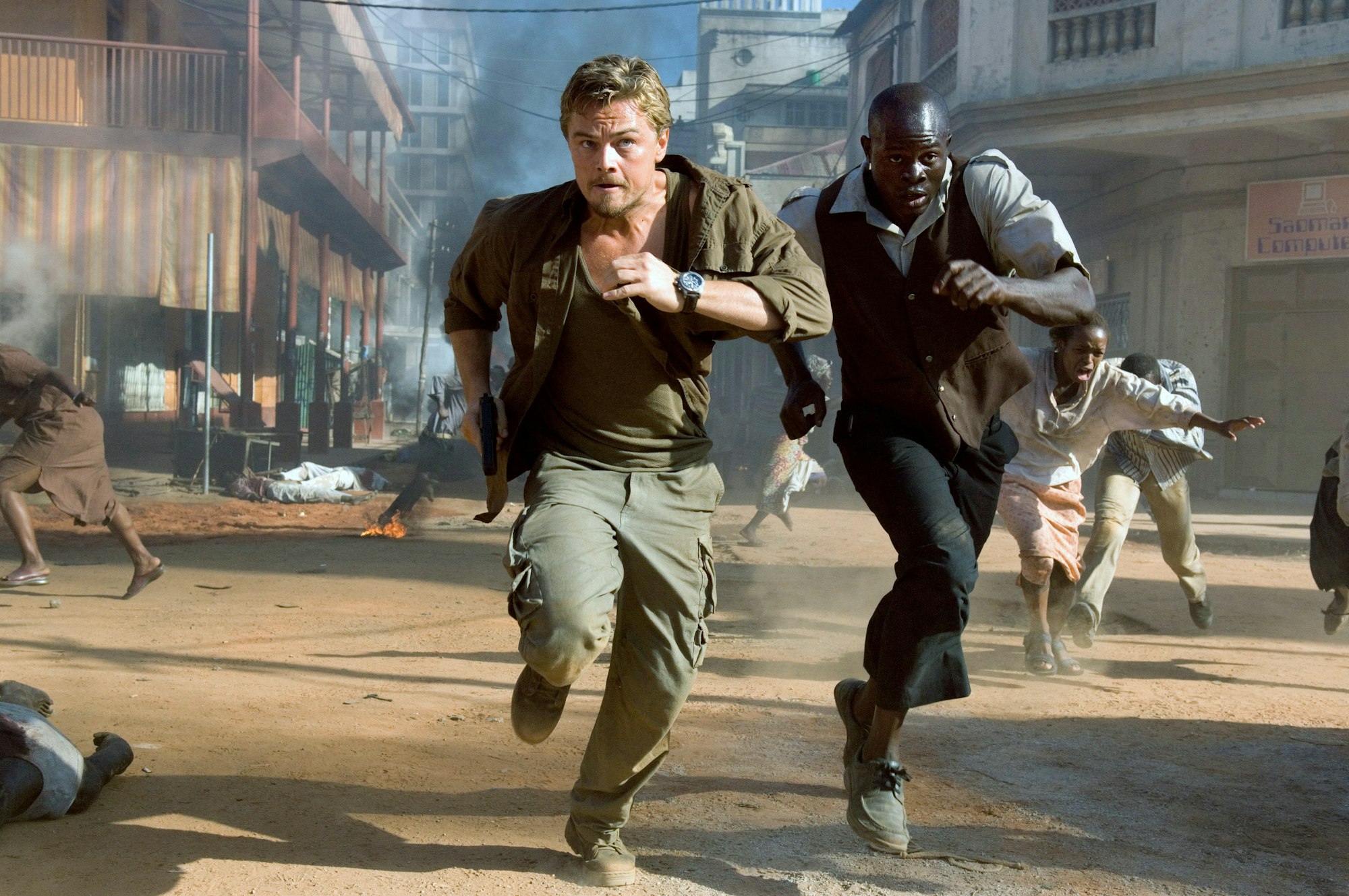 Leonardo DiCaprio und Djimon Hounsou rennen über eine verwüstete Straße.