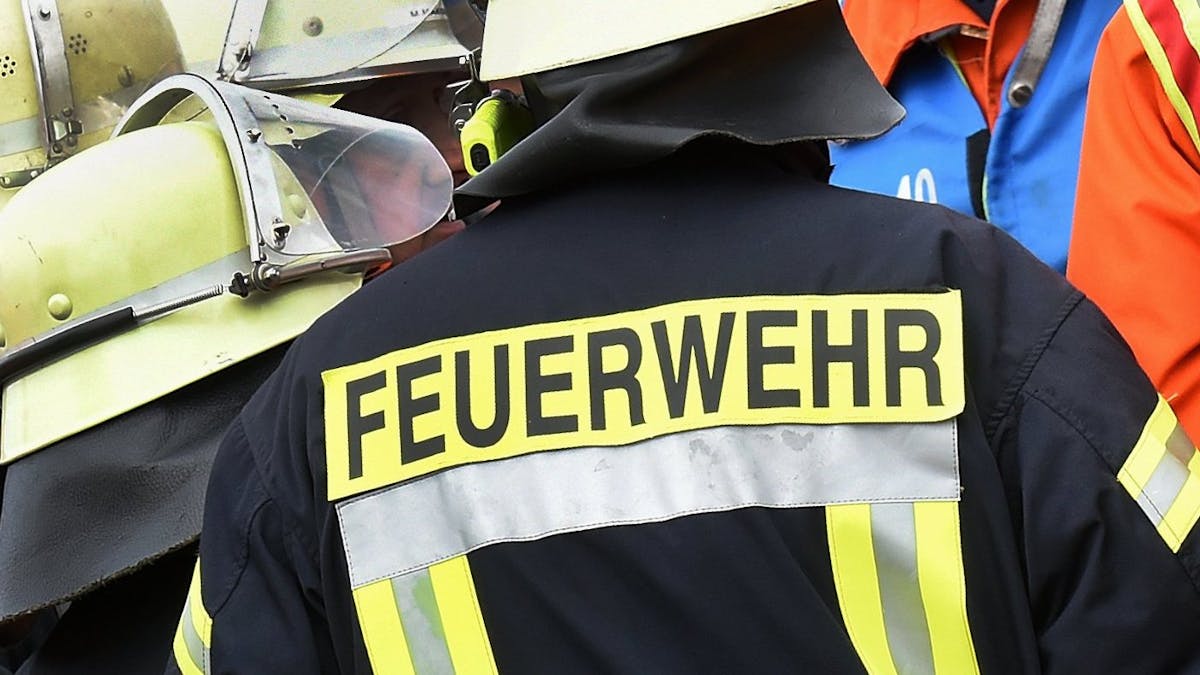 Der Schriftzug Feuerwehr steht während einer Rettungs-Übung an der Jacke eines Feuerwehrmannes, es handelt sich um ein Symbolfoto aus dem Jahr 2014