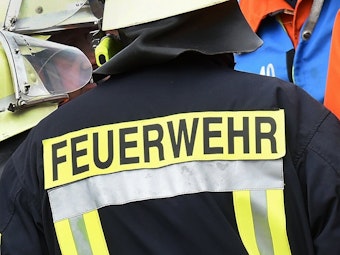 Der Schriftzug Feuerwehr steht während einer Rettungs-Übung an der Jacke eines Feuerwehrmannes.