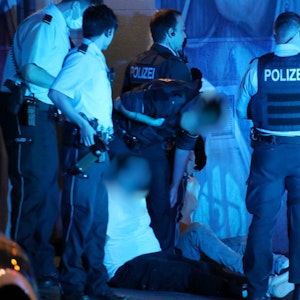 Polizisten stehen nachts am Zülpicher Platz und haben zwei Männer festgenommen.