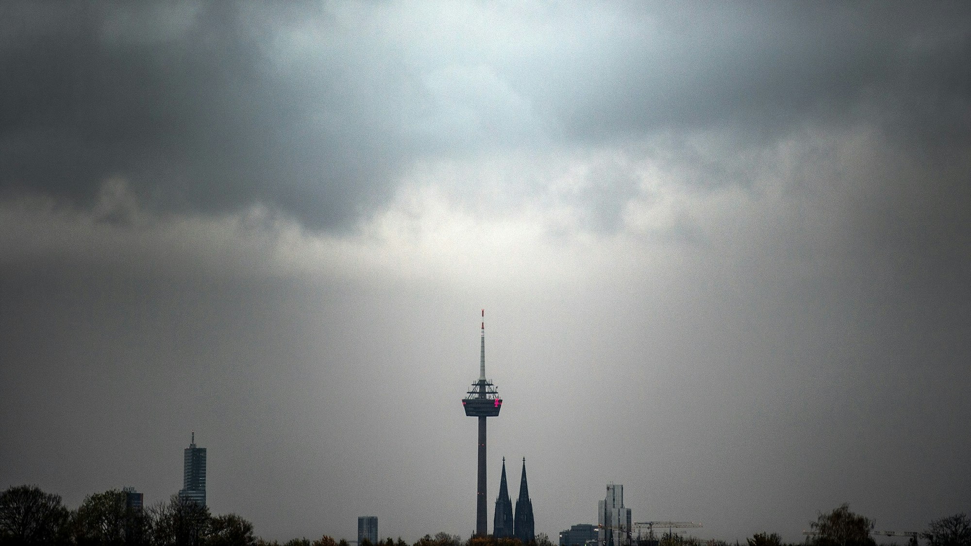 Wolken ziehen am Morgen über den Kölner Dom und den Fernsehturm.