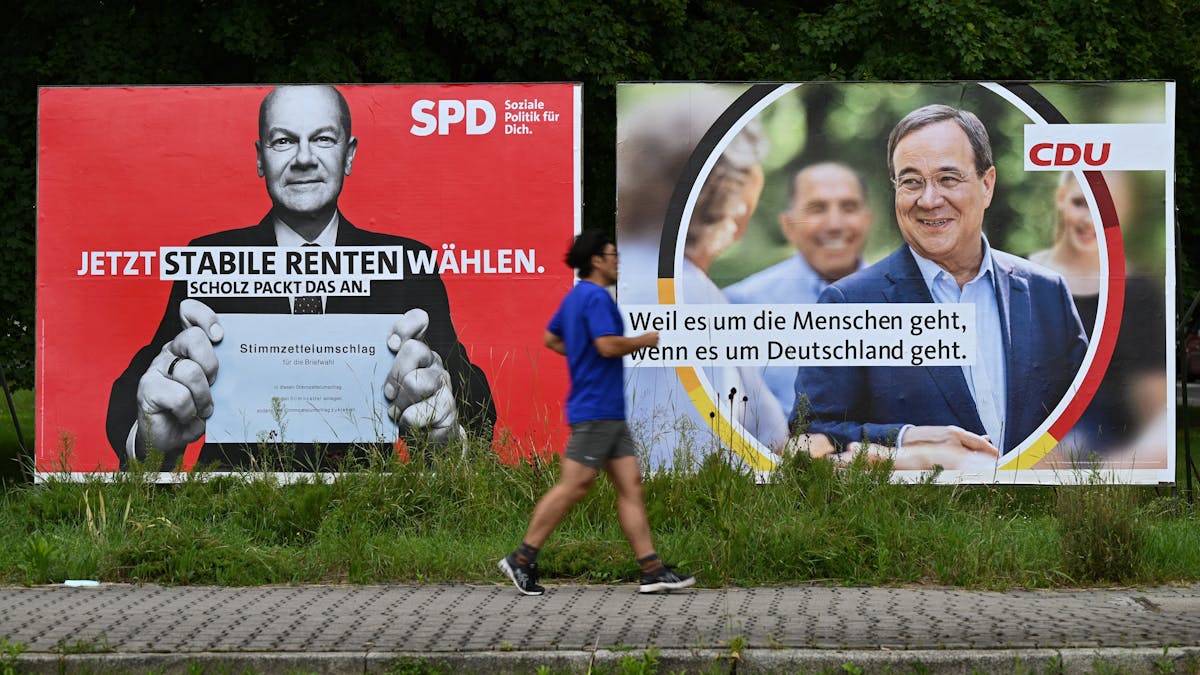 Ein Jogger läuft an großen Wahlplakaten mit den Spitzenkandidaten Olaf Scholz (SPD, l) und Armin Laschet (CDU) vorbei.