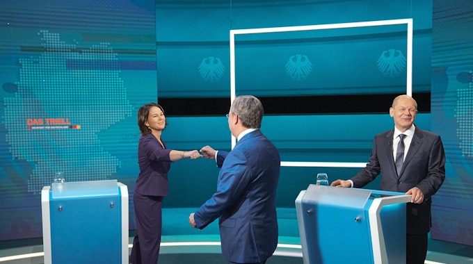 Die Kanzlerkandidaten Armin Laschet (Mitte, CDU), Annalena Baerbock (l, Bündnis 90/Die Grünen) und Olaf Scholz (SPD) begrüßen sich vor der Sendung am 29. August 2021 im Fernseh-Studio in Berlin-Adlershof.