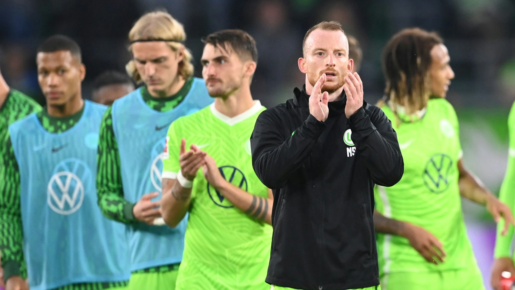 Maximilian Arnold und die Spieler des VfL Wolfsburg klatschen ihren Fans zu.