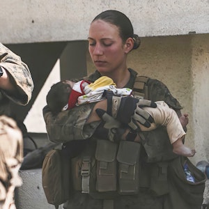 In diesem Bild vom 20. August 2021, das vom US Marine Corps zur Verfügung gestellt wurde, beruhigen Marines der 24. Marine Expeditionary Unit (MEU), darunter Sgt. Nicole Gee (links stehend) Kleinkinder während einer Evakuierung am Hamid Karzai International Airport in Kabul, Afghanistan.