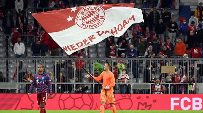 Münchens Torwart Manuel Neuer (M) schwenkt nach dem Spiel eine Bayern-Fahne mit dem Schriftzug "Wieder Dahoam".