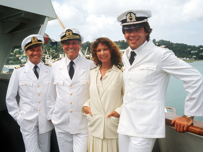 Die „Traumschiff“-Crew von 1983 (l-r) Horst Naumann als Schiffsarzt, Heinz Weiss als Kapitän, Heide Keller als Stewardess und Sascha Hehn als Steward.