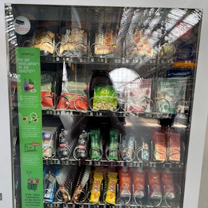 Vegan, Bio, fast abgelaufen: Im „Rettomat“ gibt es zahlreiche Snacks für Reisende. Der Automat informiert außerdem über das Problem der Lebensmittelverschwendung.