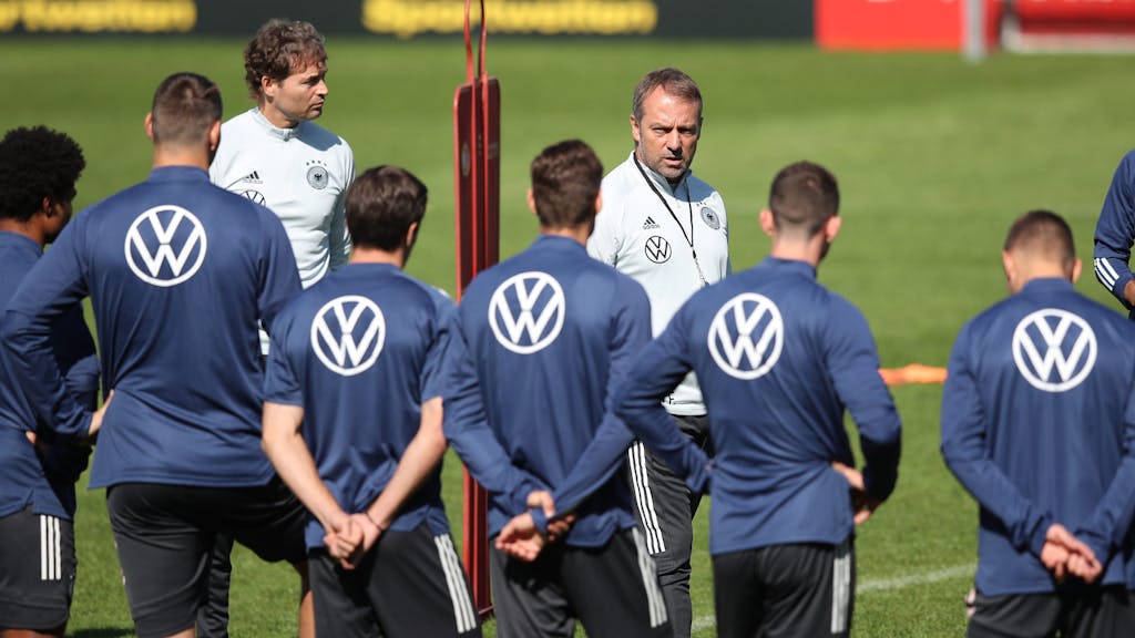 Bundestrainer Hansi Flick und Assistenztrainer Marcus Sorg sprechen mit den Spielern.