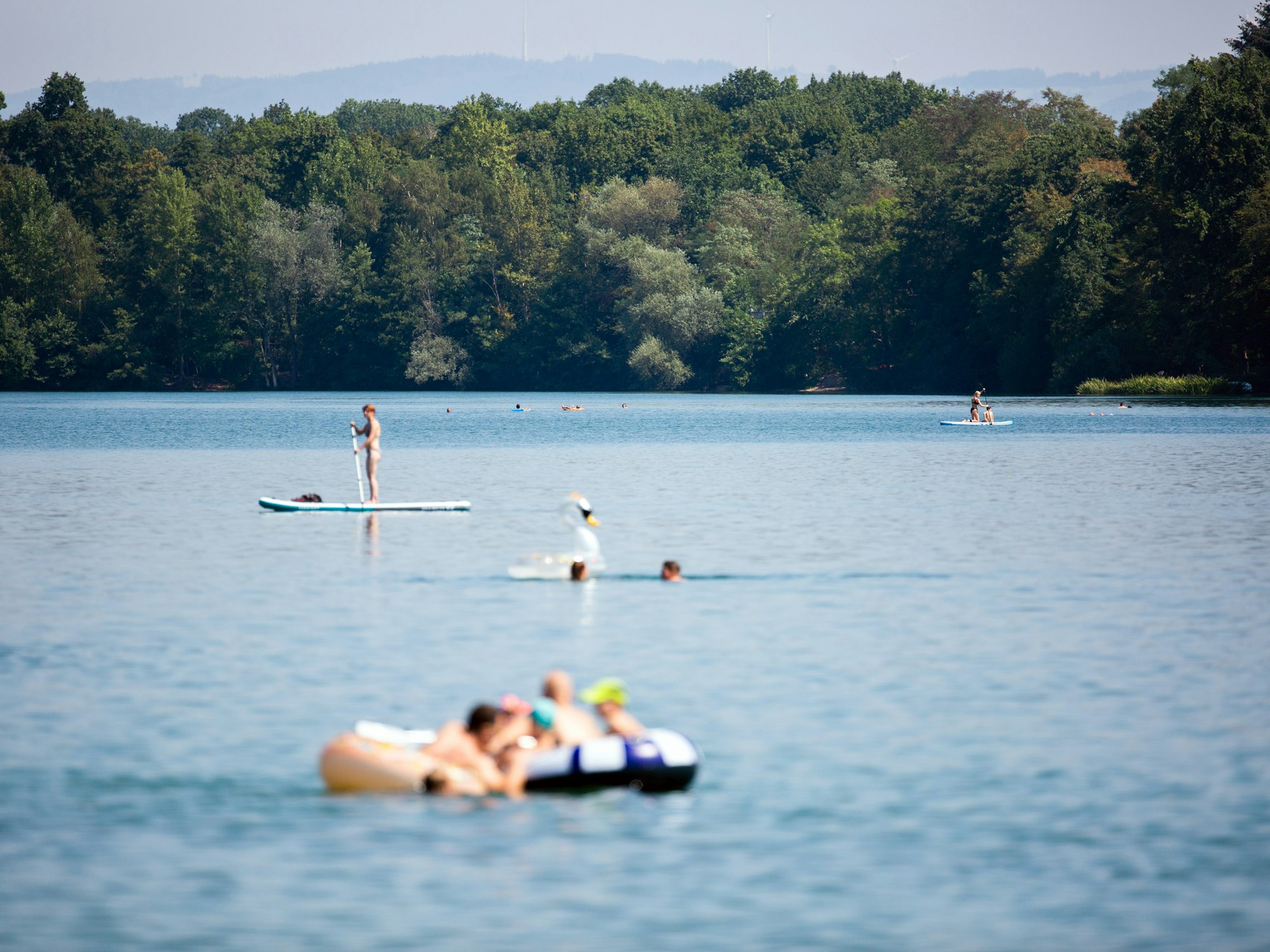 Badegäste genießen das schöne Wetter am Opfinger See in Baden-Württemberg.