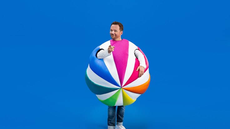 Ralf Schmitz steckt in einem Ball, dem Sat.1-Logo.