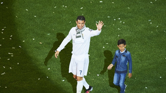 Cristiano Ronaldo und sein Sohn Cristiano Jr. laufen über den Platz von Real Madrid.