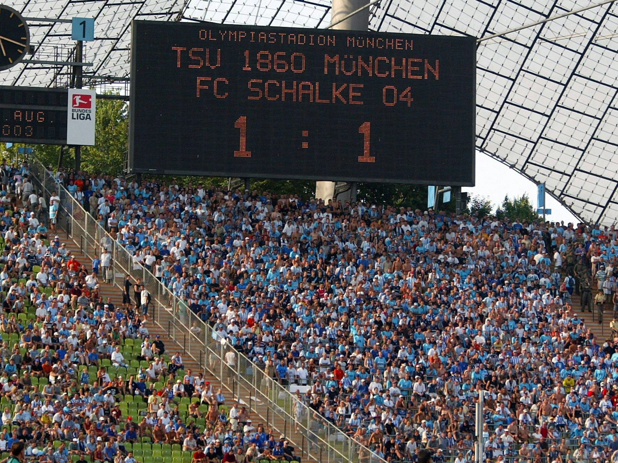 Das Bild zeigt die Anzeigetafel im Olympiastadion. Zwischen 1860 und Schalke steht es 1:1.