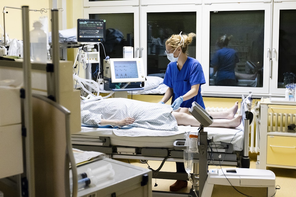Krankenschwester am Bett eines Intensivpatienten.