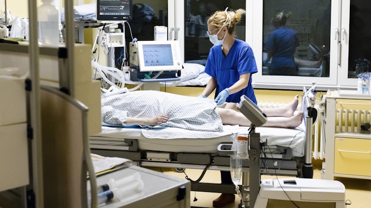 Krankenschwester am Bett eines Intensivpatienten.