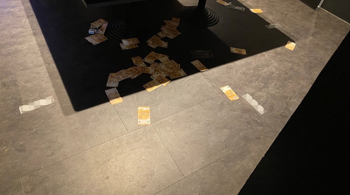 Geldscheine liegen rund um einen Spieltisch verstreut. Unter Federführung der Polizei Bonn wurden in der Nacht zum 5. September 2021 illegale Glücksspiel-Treffpunkte im Raum Siegburg ausgehoben.