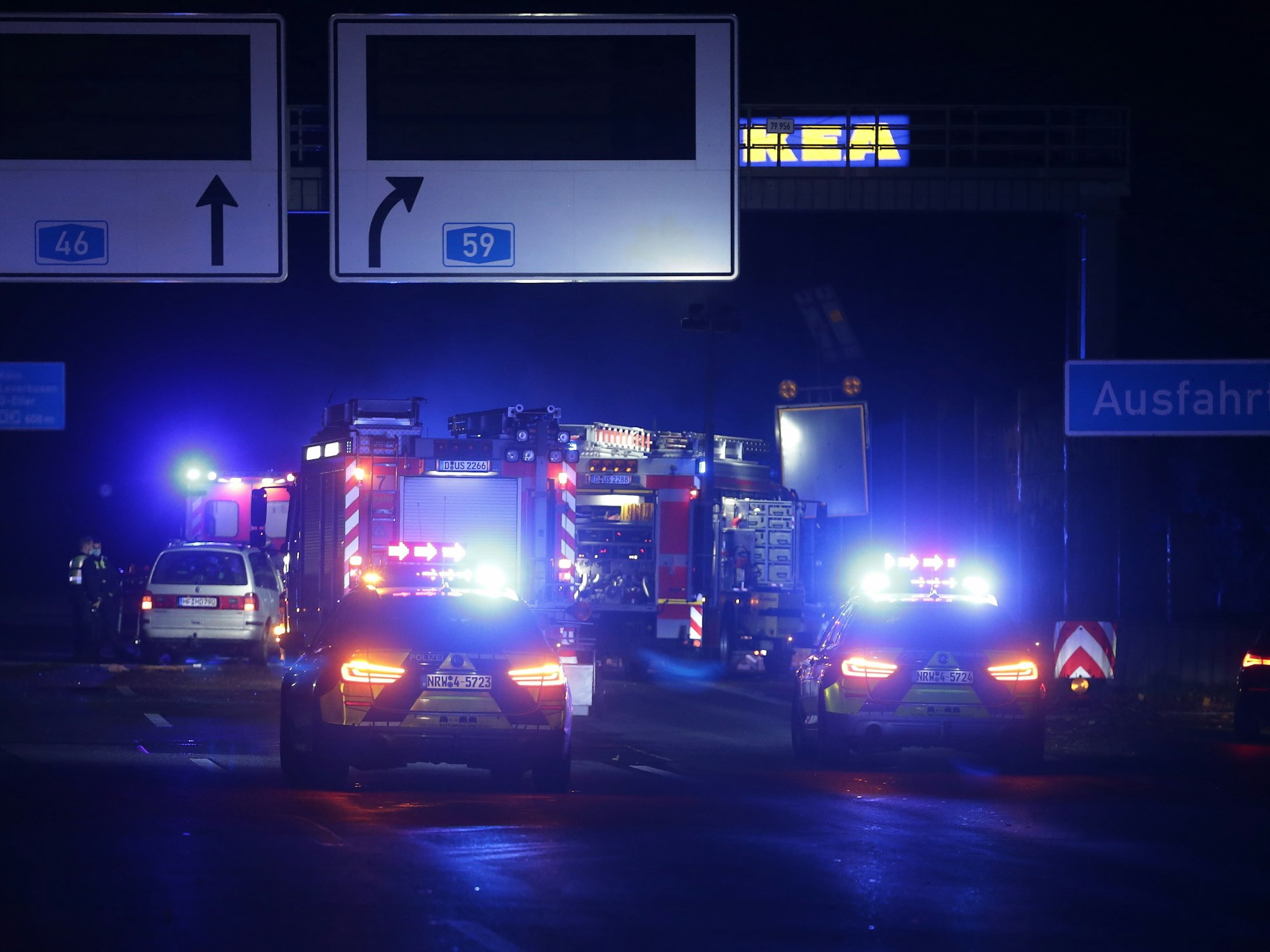 Fahrzeuge der Feuerwehr stehen mit Blaulicht auf der Autobahn.